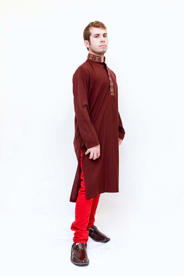 A dark red cotton shirt with tan embroidering around the neckline